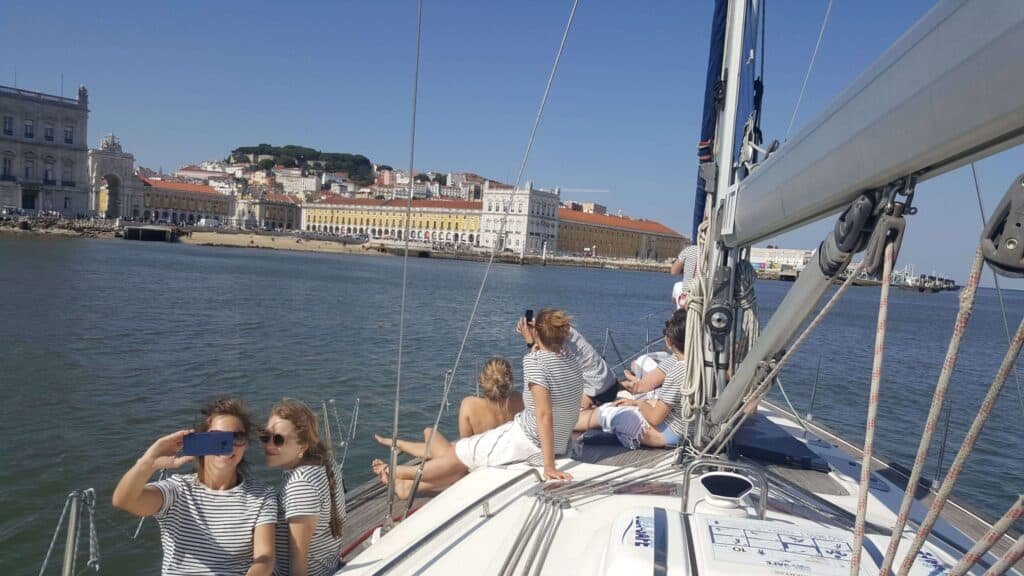 Gente en un velero contemplando la Plaza del Comercio