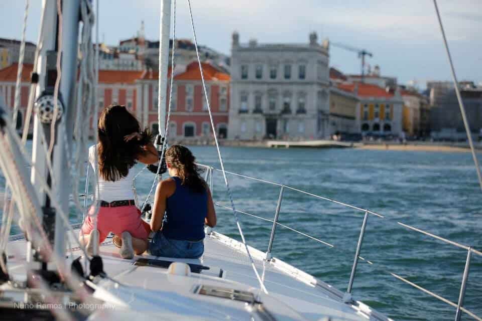 Dos mujeres en un velero contemplando la Praza del Comercio