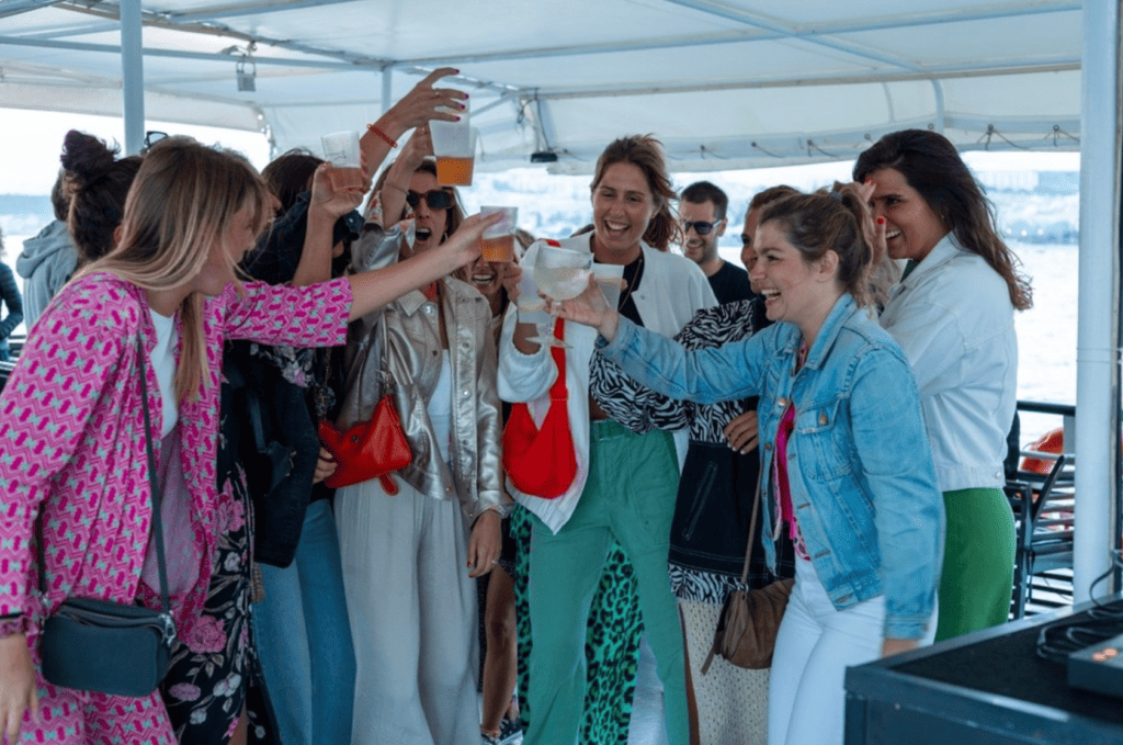 Amigas celebrando durante un paseo en barco por el río Tajo.