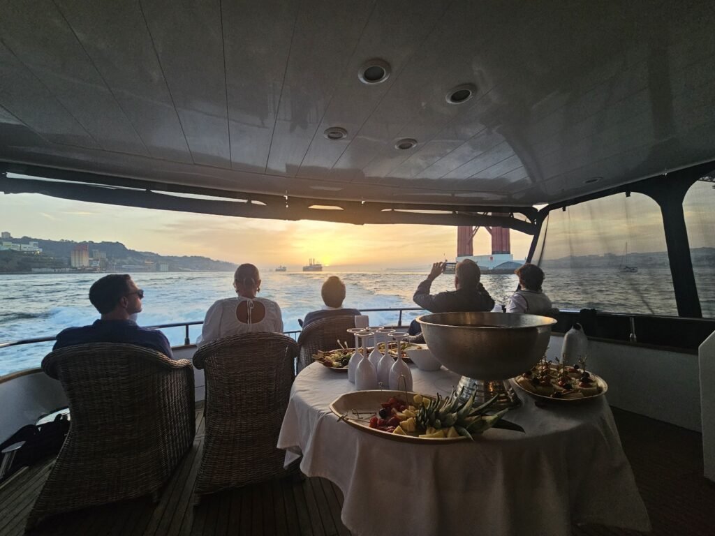 Personas sentadas en el barco tomando fotos al atardecer después de la comida.