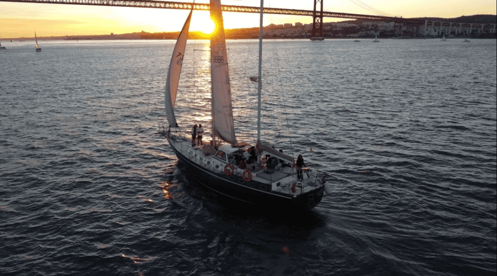 Velero al atardecer en el río Tajo con vistas a Lisboa y el puente 25 de Abril