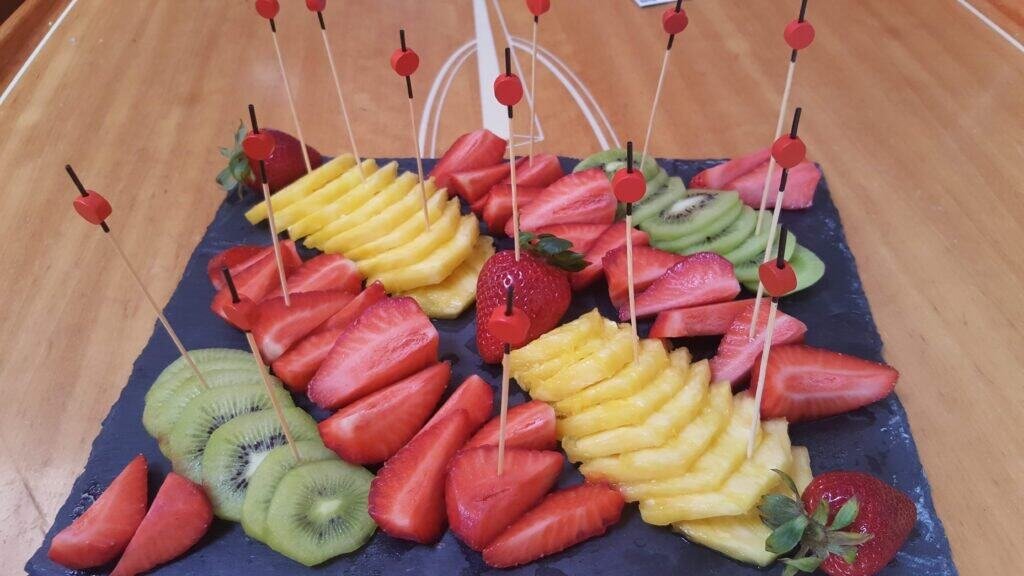 Display of boards with a variety of fruits such as kiwi, strawberries and pineapple
