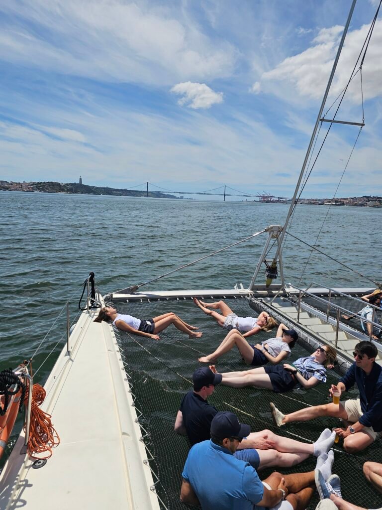 Grupo de compañeros de trabajo tomando el sol durante el evento, en una tarde soleada en Lisboa.