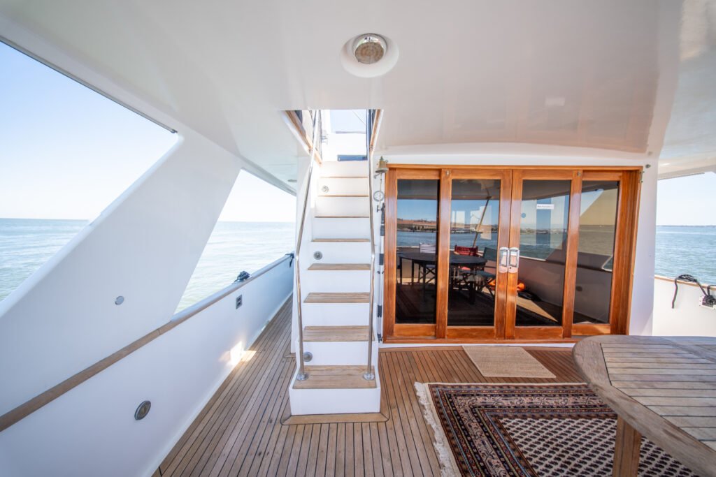 A escada de acesso ao flybridge e as portas de correr em vidro dão para o salão interior